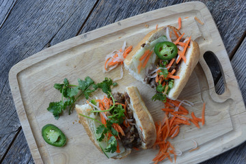 Wall Mural - Vietnamese Grilled Pork Banh Mi Sandwich on Rustic Wood Backgrou