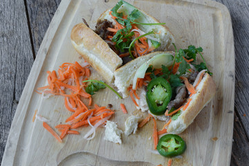 Wall Mural - Vietnamese Grilled Pork Banh Mi Sandwich on Rustic Wood Backgrou