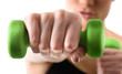 © chettythomas - Close up shot of hand by training woman with green dumbbell