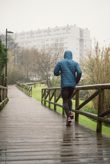 Wall Mural - Man running in the park in a rainy day