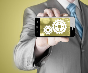 businessman show gear on smartphone to success concept