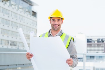 Poster - Happy architect holding blueprints outside building