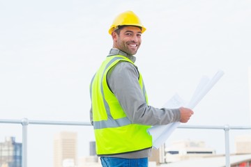 Poster - Architect in protective clothing holding blueprint outdoors