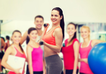 Poster - young sporty woman with light dumbbells