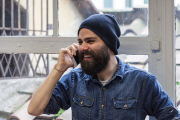 Young hipster in his studio during a phone friendly