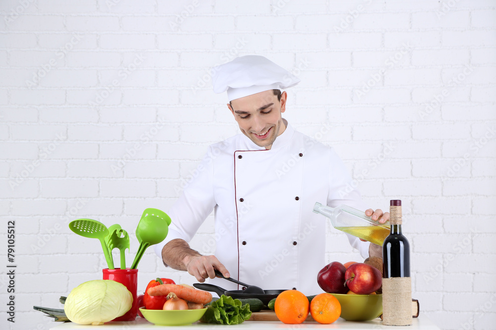 Chef at table with different products and utensil in kitchen