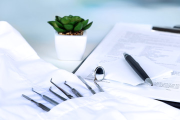 Canvas Print - Dentist tools in pocket of medical robe on table close up