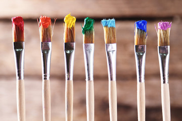 Canvas Print - Brushes with colorful paints on old wooden background