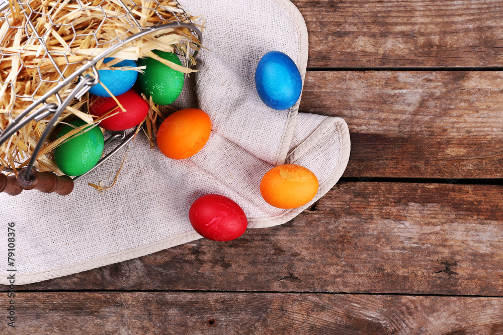 Easter eggs in basket on vintage wooden planks background