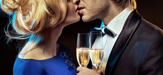 Romantic couple kissing and drinking champagne