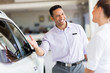 salesman selling car to a customer in showroom