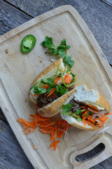 Wall Mural - Vietnamese Grilled Pork Banh Mi Sandwich on Rustic Wood Backgrou