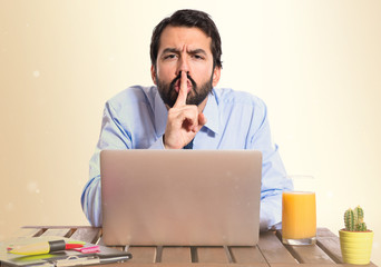 Wall Mural - Businessman in his office making silence gesture