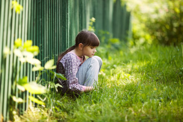 sad girl sitting on the grass