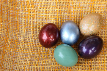 Wall Mural - Colorful easter eggs on bamboo weave sheet background.