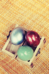 Wall Mural - Colorful easter eggs in small wood case on bamboo weave sheet ba