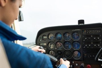 Young woman airplane pilot inside cockpit plane.