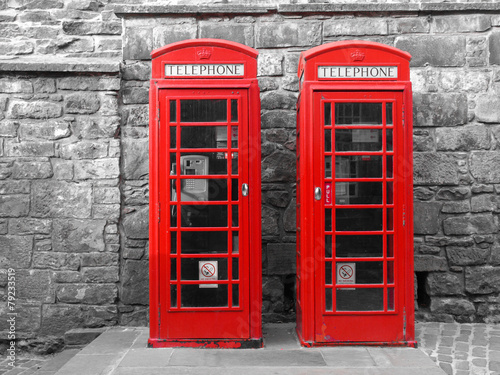 dwie-londynskie-budki-telefoniczne-na-tle-czarno-bialych-cegiel