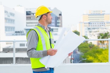 Poster - Architect in protective workwear holding blueprints outdoors