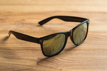 Black sunglasses on a wooden table