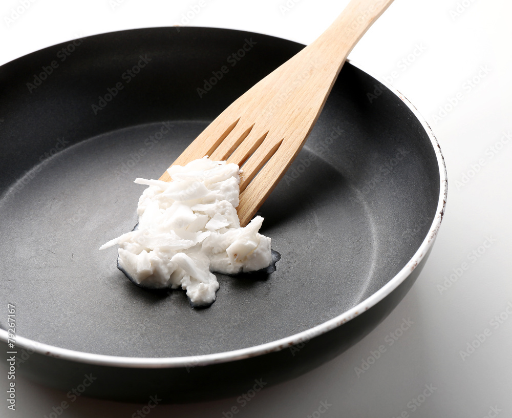 Coconut oil in frying pan isolated on white