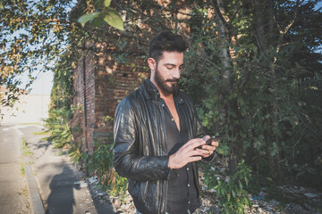 Wall Mural - young handsome attractive bearded model man using smartphone