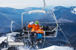 © Sergey Novikov - Man skier with child lift on ropeway chair
