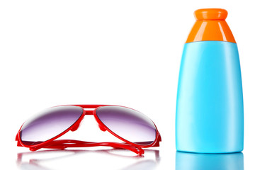 Bottle of suntan cream with sunglasses isolated on white