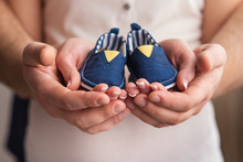Newborn Shoes In  Parents Hands