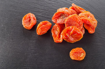 A heap of dried apricots on  dark background