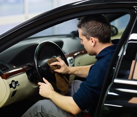 Poster - Worker on a car wash cleaning car interior