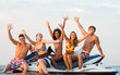 © Nejron Photo - Group of happy multi ethnic friends sitting on a jet ski