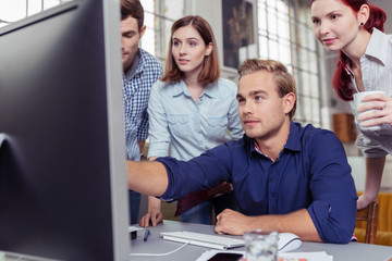 mann zeigt seinen kollegen etwas am computer