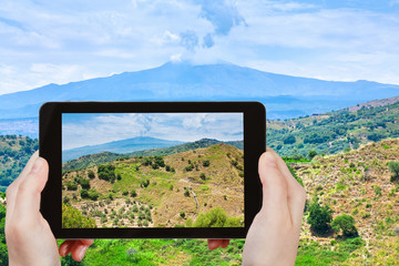 Wall Mural - tourist taking photo of rural landscape with Etna