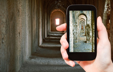 Canvas Print - tourist taking photo of ancient arcades in Temple