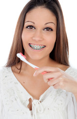 Wall Mural - Attractive young woman with brackets cleaning her teeth