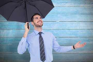Aufkleber - Happy businessman sheltering with a black umbrella