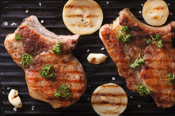 Two juicy grilled pork steak in a pan grill  horizontal top view