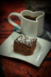 Brown cake with coffe on white plate