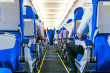 Interior Of Airplane With Passengers On Seats