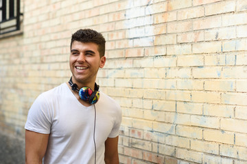 Canvas Print - young man in urban background listening to music with headphones