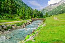 Mountain Stream And The High Peaks Of The Austrian Alps