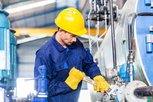 Technician In Factory At Machine Maintenance