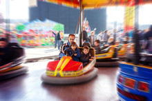 Father And His Two Sons,l Having A Ride In The Bumper Car At The