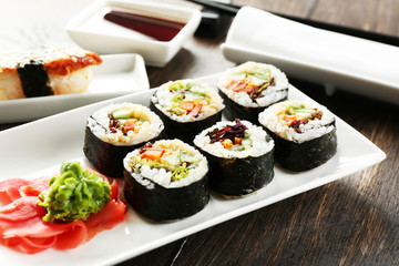 Wall Mural - Vegetarian sushi rolls on plate, on wooden background