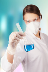 Wall Mural - Woman in laboratory holding chemical liquid in glass flask