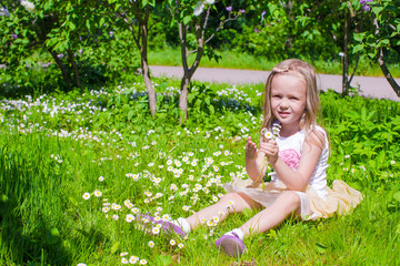 Wall Mural - Little adorable girl enjoying beautiful day in blooming garden