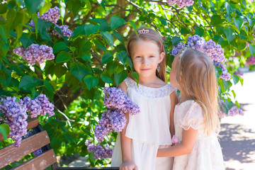 Wall Mural - Little adorable girls in lush park in summer vacation