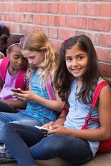 Wall Mural - Cute pupils using mobile phone