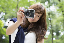 A Woman Taking A Picture With Camera In Park